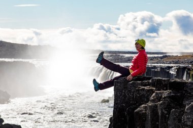 Kadın bir şelale arka plan üzerinde. İzlanda