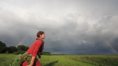 Ulusal elbiseli bir kız çiçek çelenk atar. Yavaş hareket