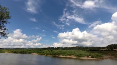 Bulutlar mavi gökyüzünde koşur. Zaman atlamalı. Nehrin altında akar ve orman büyür