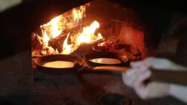 Şöminede yemek pişirmek. Tavada krepler fırında ateşte kızartılır.