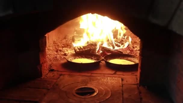 Cuisiner dans la cheminée. Crêpes dans une casserole sont frites sur un feu dans le four 