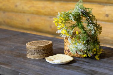 Çiçekli hasır sepet ahşap bir masanın üzerinde duruyor