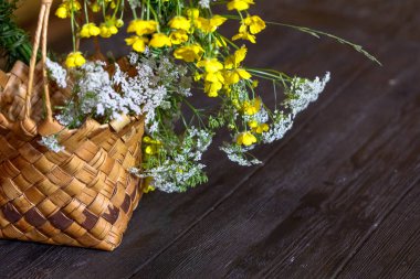 Çiçekli hasır sepet ahşap bir masanın üzerinde duruyor