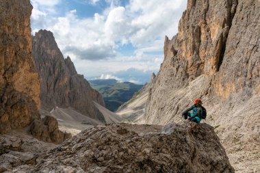 Dağlarda genç bir adam sırt çantasıyla seyahat ediyor. İtalya 'daki Dolomitlerin dağ manzarası çok güzel.