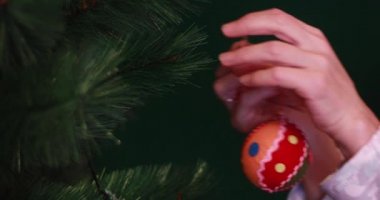 Kadın elleri yılbaşı oyuncaklarını Noel ağacına asar. Noel ve Noel Baba