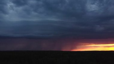 Hava fotoğrafçılığı. Hava açık ve gün batımına karşı. Sağanak yağmur yağıyor. Elektrik ışıkları gökyüzünü aydınlatıyor