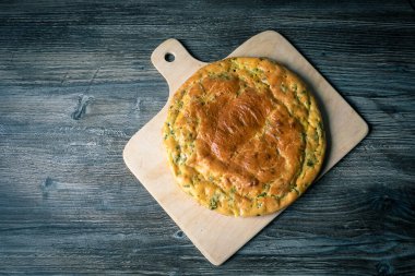 Taze lezzetli turta masanın üzerindeki kesme tahtasının üzerinde duruyor. Sıcak yemek.