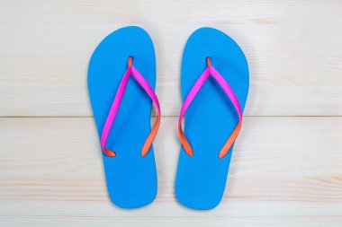 Ahşap arka plan üzerinde izole mavi flip flop. Üstten görünüm