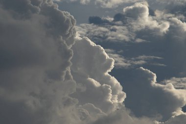 Güneş çarpıcı bulutları aydınlatır ve güzel gümüş çizgiler yaratır. Derin ve atmosferik, resmedilmiş gökyüzü