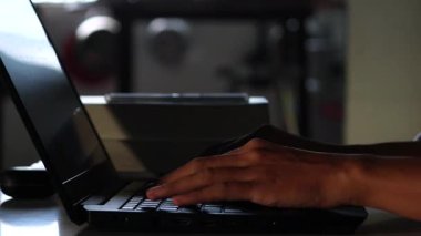 Bir insanın ellerinin gece karanlık bir odada dizüstü bilgisayara klavye yazarken, ekranın ışığı parmakları aydınlatırken, geç saatlere kadar çalışmayı ya da kodlamayı temsil ederken gerçek zamanlı videosu..