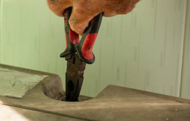 Bir şeyi kavramak için eski, paslı pense kullanan, el emeği, onarım, inşaat ya da DIY projelerini temsil eden yıpranmış bir işçinin yakın çekimi..