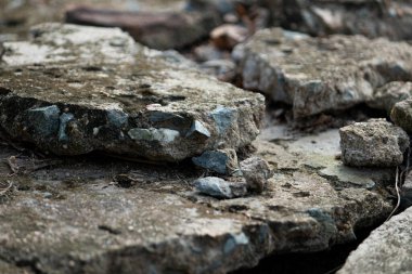 Close-up of broken concrete rubble pieces, creating a rough abstract texture background that represents destruction, decay, or a grunge style