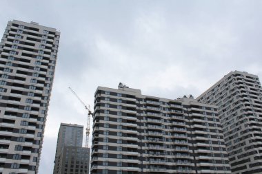 Ukrayna 'nın başkenti Kyiv' deki yüksek binaların arka planında modern bir ofis binası vinci ile inşa ediliyor.