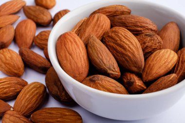 Beyaz tabakta badem fındık arka plan üzerinde yakın çekim