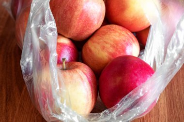 Elma meyve ahşap masa üzerinde plastik torba