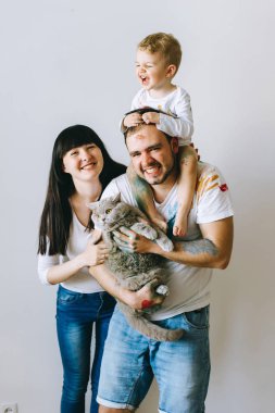 Genç aile evlat ve kedi ile oynadıktan sonra beyaz bir arka plan üzerine boyar