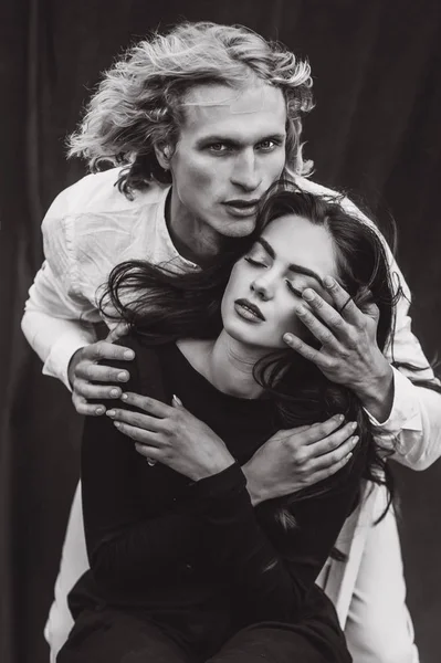 beautiful young  couple on a black background is full of emotions