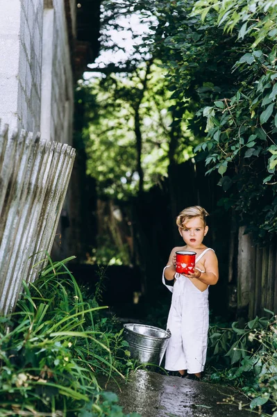 Μικρό Ξανθό Αγόρι Κόκκινη Κούπα Και Έναν Κουβά Για Φόντο — Φωτογραφία Αρχείου