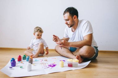 Baba ve çocuğun boya renkleri ile oynuyordu