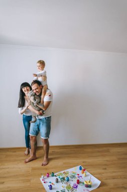 Genç aile evlat ve kedi ile oynadıktan sonra beyaz bir arka plan üzerine boyar