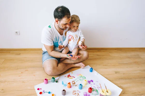 Baba ve çocuğun boya renkleri ile oynuyordu