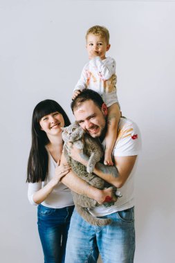 Genç aile evlat ve kedi ile oynadıktan sonra beyaz bir arka plan üzerine boyar