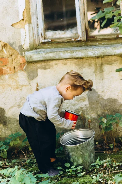 Little Blond Boy Red Mug Bucket Background — Stock Photo, Image