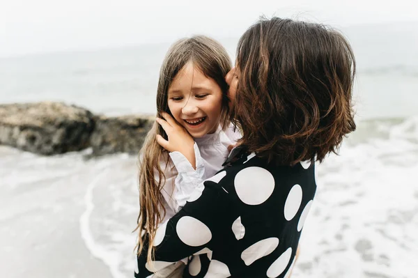 young beautiful mom and daughter on the  sea beach