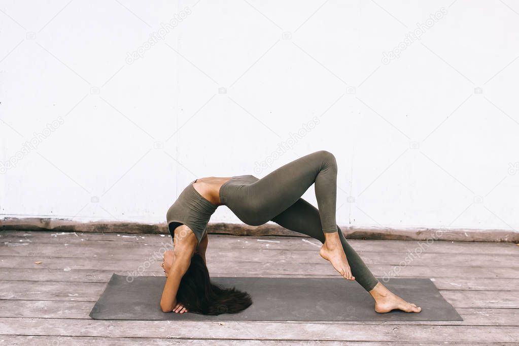 Attractive young woman in yoga pose on white background