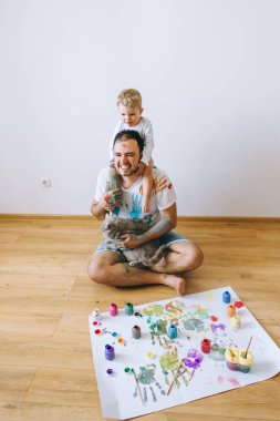 Baba ve çocuğun boya renkleri ile oynuyordu