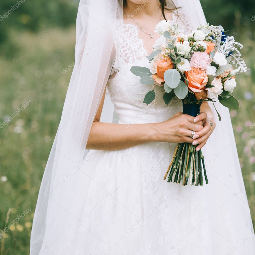 Beautiful wedding bouquet in hands of the bride