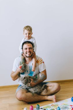 Baba ve çocuğun boya renkleri ile oynuyordu