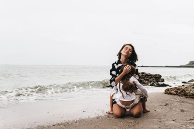 Anne ve kızı kumlu sahilde rahatlatıcı