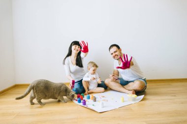 Ebeveynler ve boyalar ile bir poster ve başka bir resim bir kedi ile oğlu