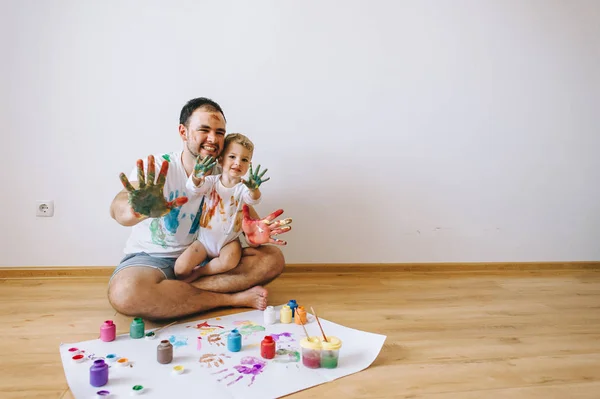 Father and son playing with paint colors