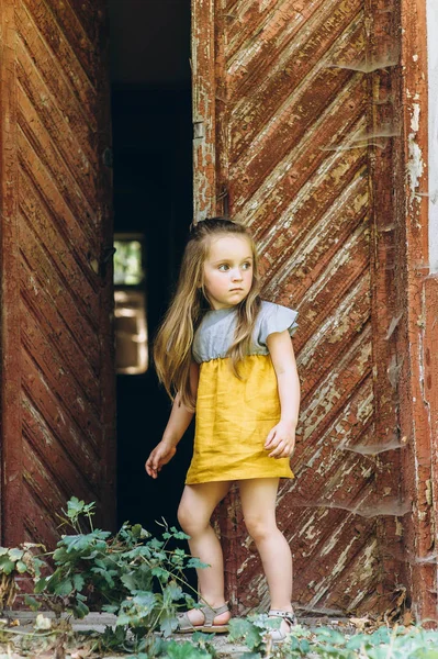 Menina Bonita Vestido Amarelo Perto Uma Porta Madeira — Fotografia de Stock