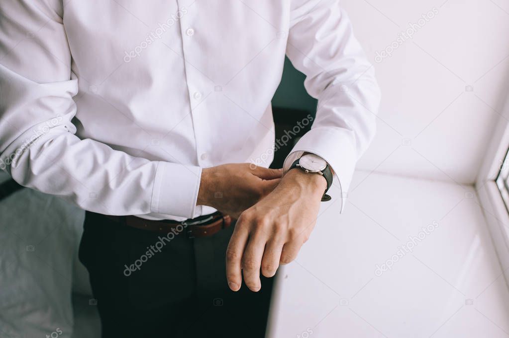 Man fastens his cufflinks close-up. Businessman or fiance preparing himself for going out.