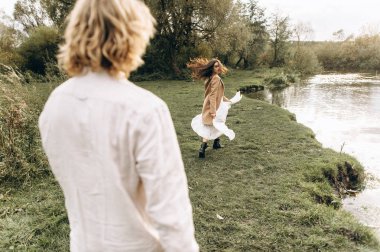 Ücretsiz giysili güzel genç çift çim Gölü yakınındaki bir güneşli yaz günü geldi