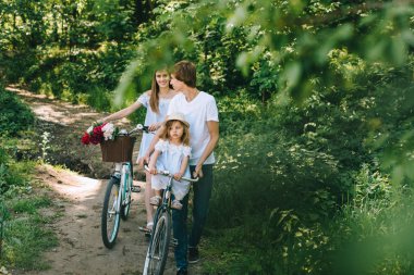 Mutlu genç aile dışında birlikte vakit. Baba Anne ve çocuklarının yeşil park
