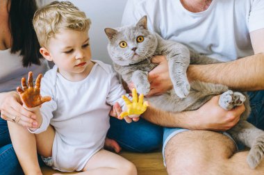 mutlu bir aile ve bir kedi bir poster ve başka bir boya ile resim