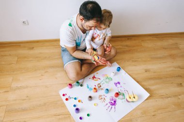 Baba ve küçük çocuk fivr yıl eğleniyor evde boyama