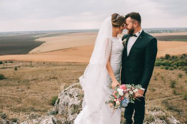 mutlu genç damat ve gelin birbirlerine açık havada gülümseyen