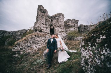 mutlu genç damat ve Gelin el ele tutuşarak ve gülümseyen