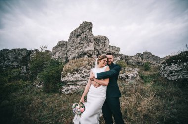 mutlu genç damat ve gelin açık havada kucaklayan