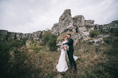 mutlu genç damat ve gelin sarılma ve gülümseyen 