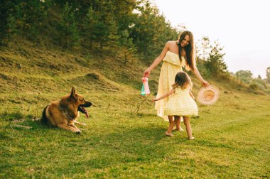 küçük kızı ve onların köpek ile Genç Anne yürüyüş