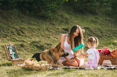 Genç Anne ve kızı bir piknik ile a Alman çoban köpek
