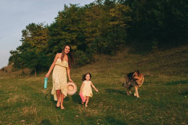 küçük kızı ve onların köpek ile Genç Anne yürüyüş