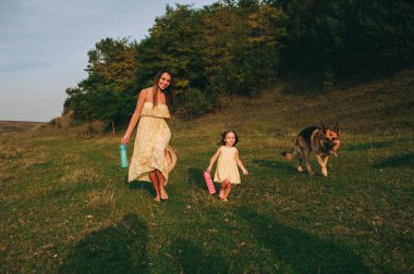 küçük kızı ve onların köpek ile Genç Anne yürüyüş
