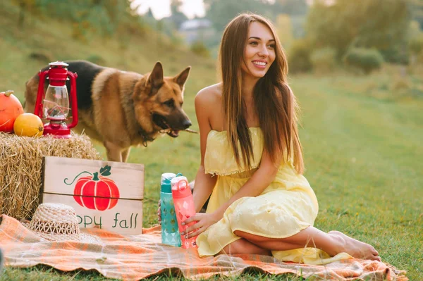 young woman at a picnic with a German shepherd dog